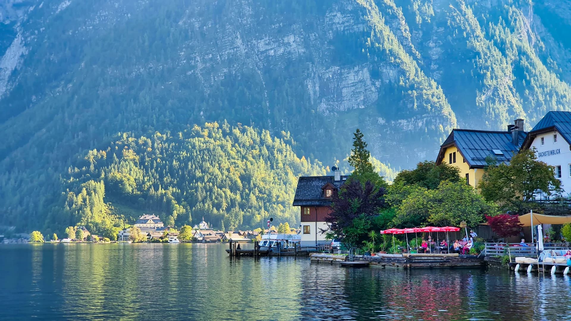Case tradizionali sulla riva del lago ad Hallstatt in Austria circondate da ripide montagne verdi