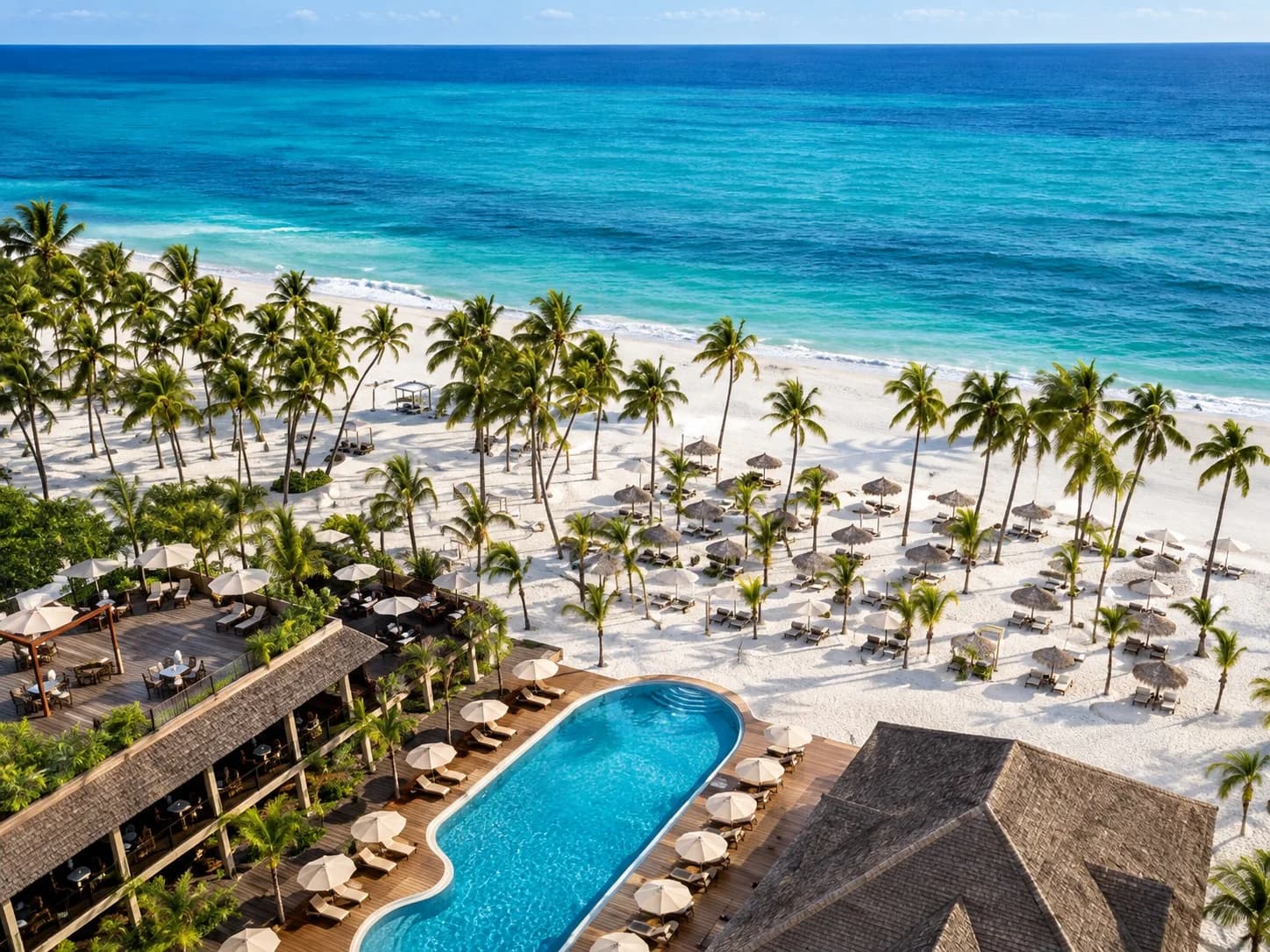 Resort tropicale in Tanzania con grande piscina, spiaggia di sabbia bianca tra le palme e mare turchese